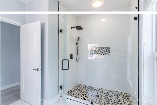 bathroom with hardwood / wood-style flooring and a shower with shower door