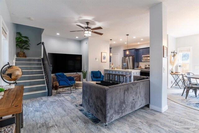 living room featuring ceiling fan and light hardwood / wood-style floors