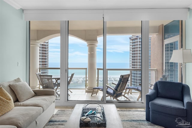 living room with floor to ceiling windows, a water view, and plenty of natural light