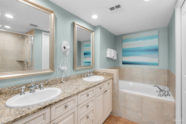 bathroom with vanity and independent shower and bath