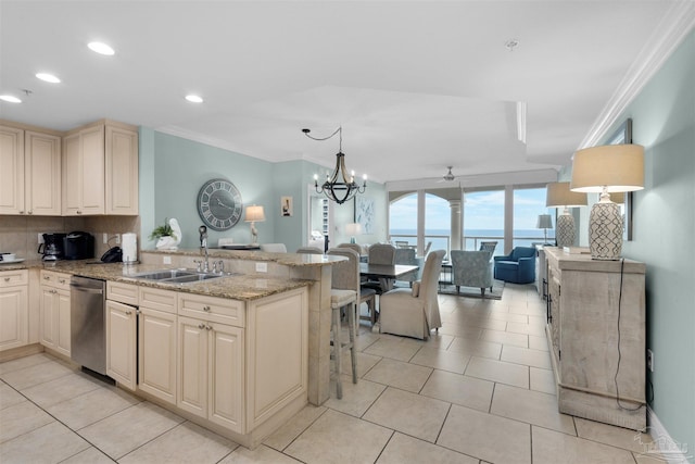 kitchen featuring sink, a water view, decorative backsplash, decorative light fixtures, and stainless steel dishwasher