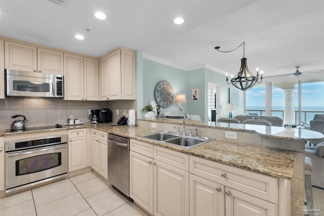 kitchen featuring sink, a water view, hanging light fixtures, kitchen peninsula, and stainless steel appliances