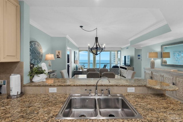 kitchen with sink, crown molding, stone counters, decorative backsplash, and a chandelier