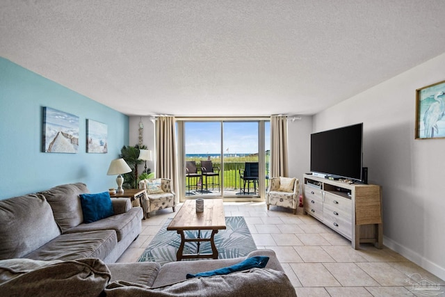 living area featuring expansive windows, a textured ceiling, baseboards, and light tile patterned floors