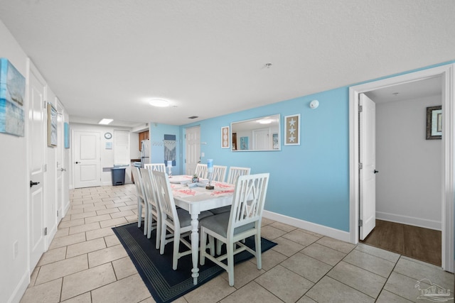 dining room with light tile patterned floors and baseboards