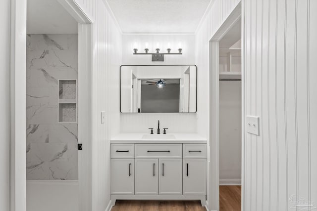 full bathroom featuring vanity, ceiling fan, and a shower stall