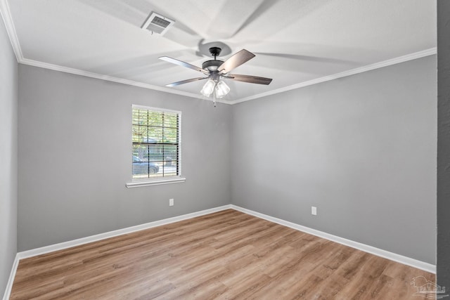 spare room with visible vents, ornamental molding, light wood-style floors, and ceiling fan