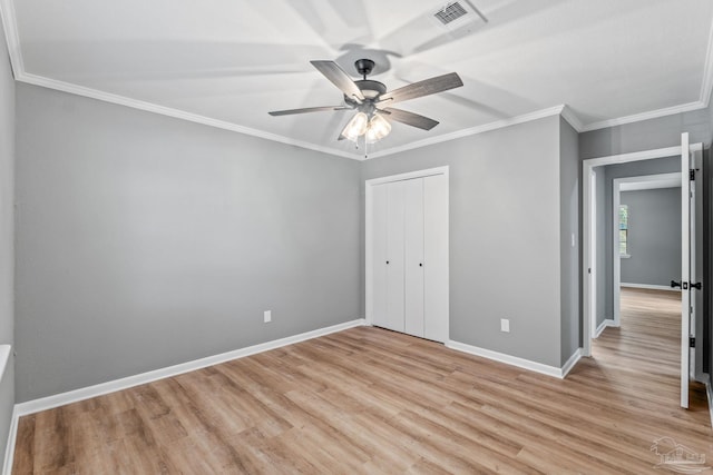 unfurnished bedroom with visible vents, crown molding, a closet, baseboards, and light wood finished floors