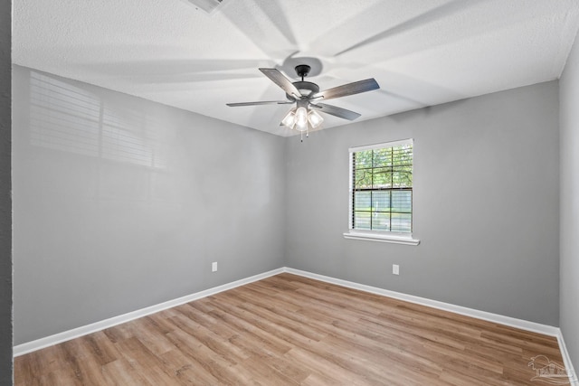 spare room featuring baseboards, ceiling fan, and light wood finished floors