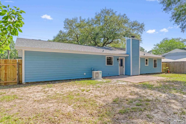 back of house featuring ac unit, a patio area, fence, and a chimney