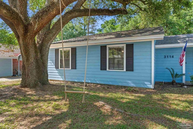 view of home's exterior featuring a lawn and roof with shingles