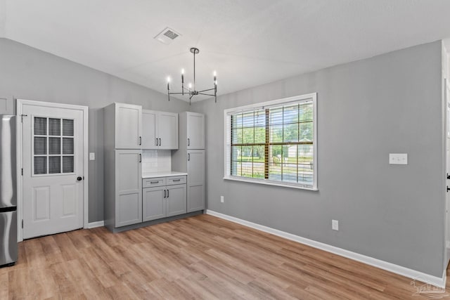 kitchen with an inviting chandelier, light wood-style flooring, baseboards, and visible vents
