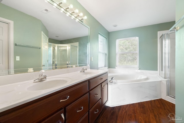 bathroom with double vanity, shower with separate bathtub, and hardwood / wood-style flooring