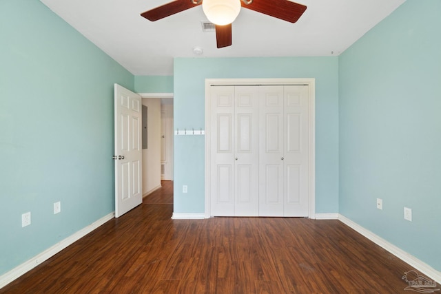 unfurnished bedroom with dark hardwood / wood-style flooring, a closet, and ceiling fan