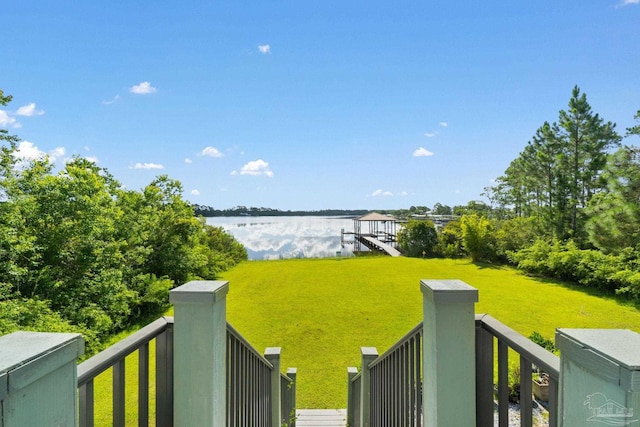 view of yard with a water view and a dock