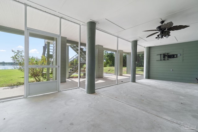 interior space with a water view and ceiling fan