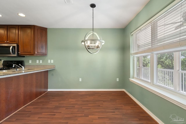 kitchen featuring dark hardwood / wood-style flooring, sink, a chandelier, and decorative light fixtures