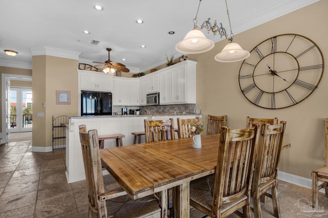 dining area featuring ceiling fan, dark tile patterned floors, and ornamental molding