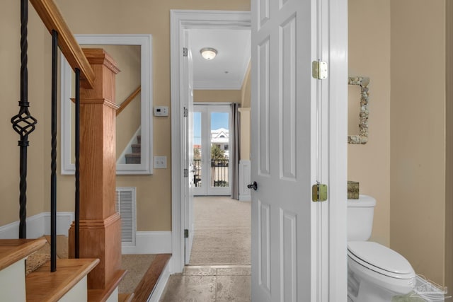 bathroom with tile patterned floors, crown molding, and toilet