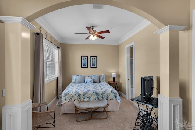 carpeted bedroom with decorative columns, crown molding, and ceiling fan