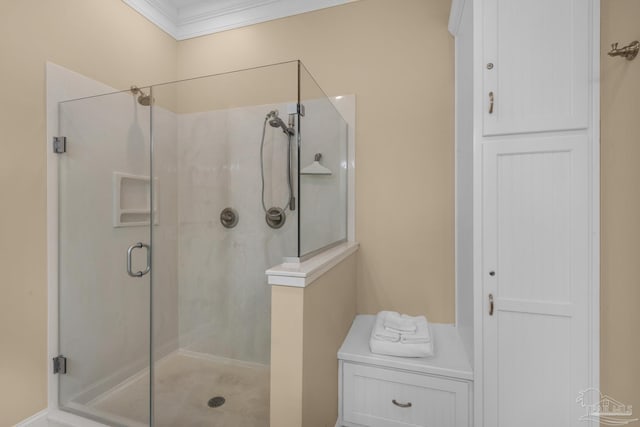 bathroom featuring a shower with door and crown molding