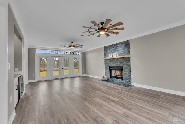 unfurnished living room with crown molding, ceiling fan, a fireplace, and hardwood / wood-style floors