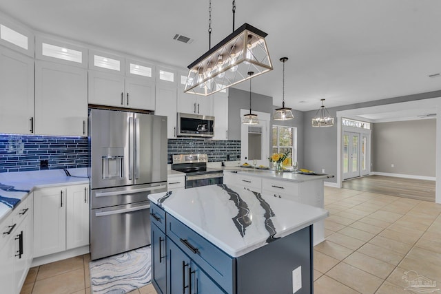 kitchen with pendant lighting, white cabinetry, appliances with stainless steel finishes, and a center island