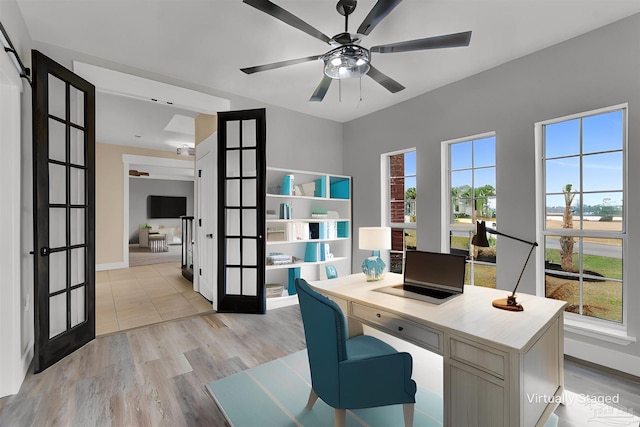 office with light hardwood / wood-style flooring, french doors, and ceiling fan