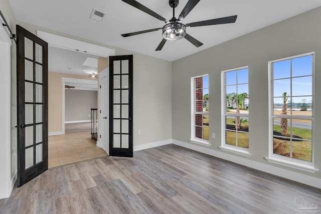 spare room featuring light hardwood / wood-style floors, french doors, and ceiling fan