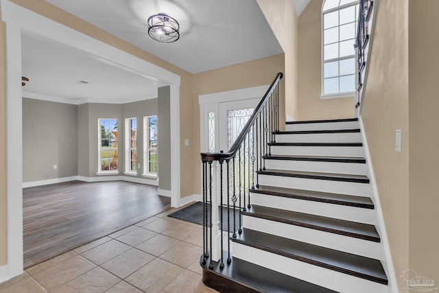 entrance foyer featuring ornamental molding and light tile patterned flooring