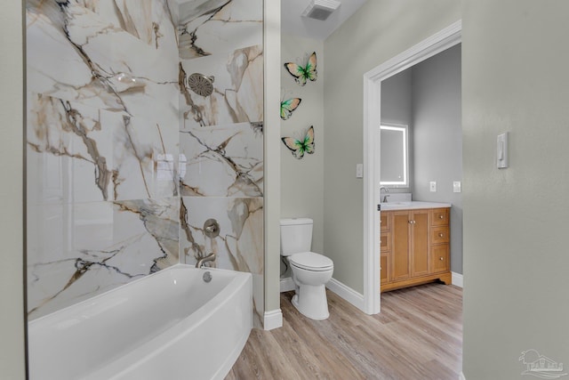 full bathroom featuring wood-type flooring, tiled shower / bath, vanity, and toilet