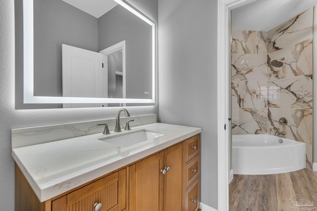 bathroom featuring vanity, hardwood / wood-style flooring, and a tub