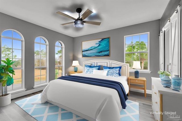 bedroom with light hardwood / wood-style floors and ceiling fan