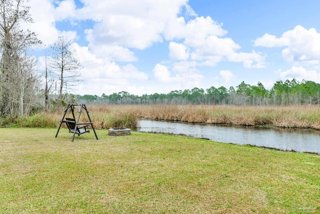 view of yard with a water view and an outdoor fire pit