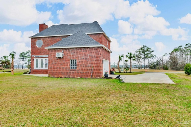 back of house featuring a yard and a garage