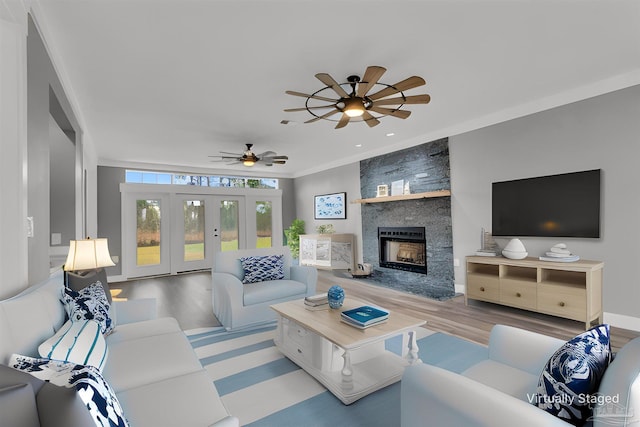 living room featuring a fireplace, crown molding, light hardwood / wood-style flooring, and ceiling fan