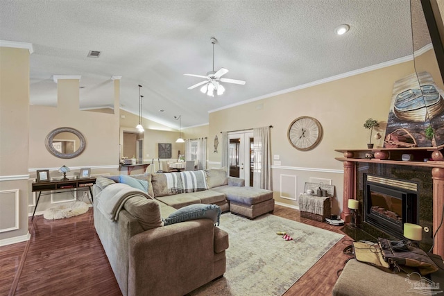 living room with lofted ceiling, dark wood-style flooring, crown molding, french doors, and a fireplace