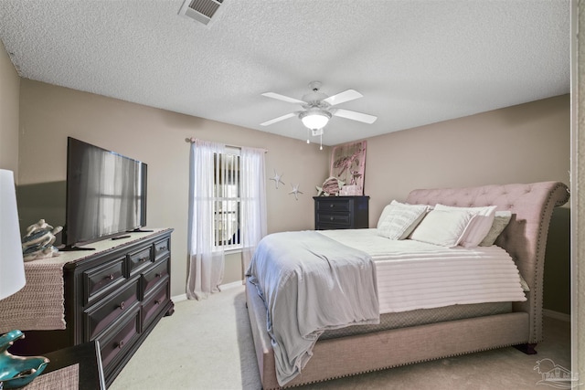 bedroom featuring visible vents, light carpet, ceiling fan, a textured ceiling, and baseboards