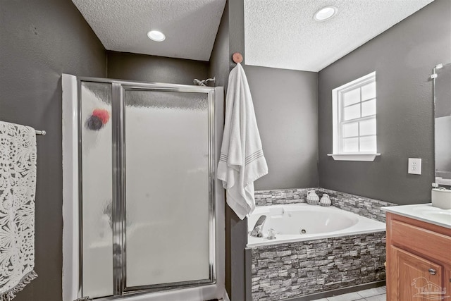 full bathroom featuring a shower stall, vanity, a whirlpool tub, and a textured ceiling