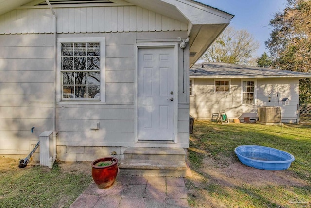 property entrance with central AC and a lawn