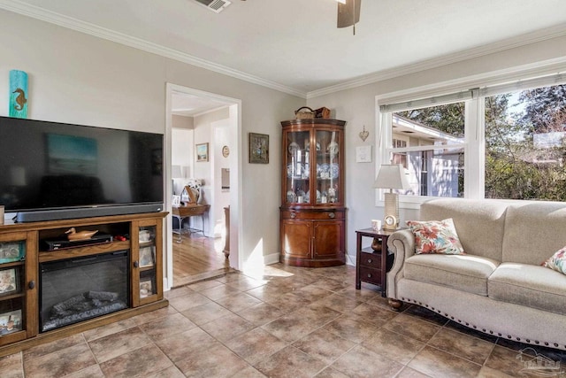 living area featuring baseboards, ornamental molding, ceiling fan, and tile patterned floors