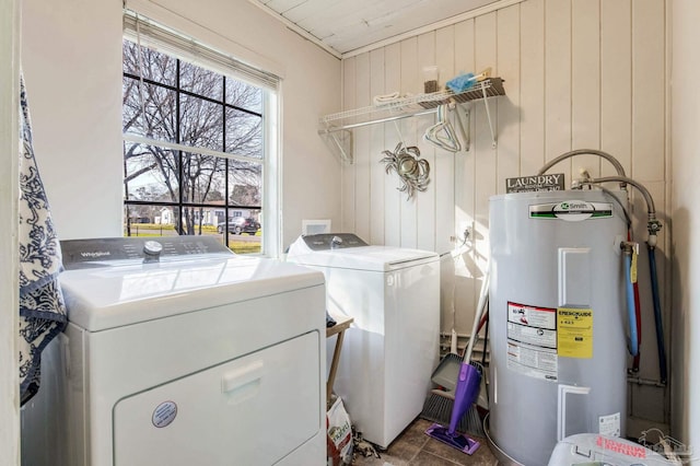 washroom with laundry area, electric water heater, independent washer and dryer, and wooden walls