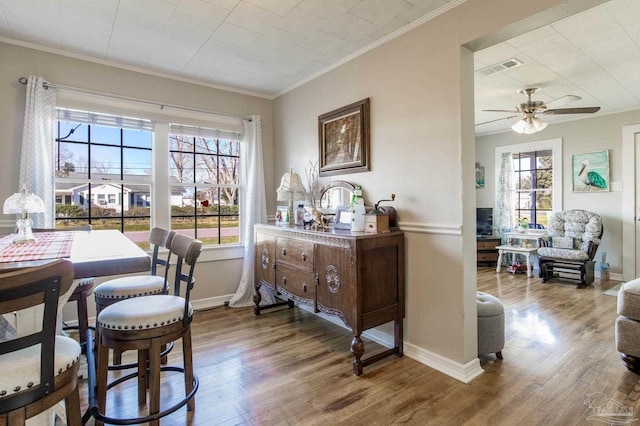 dining area with ornamental molding, wood finished floors, and a wealth of natural light