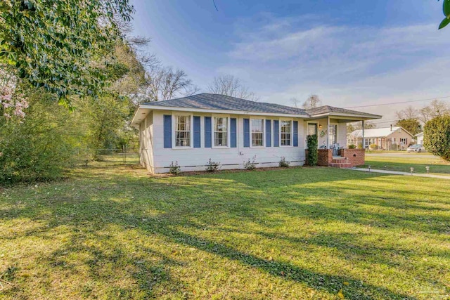 ranch-style house with fence and a front lawn