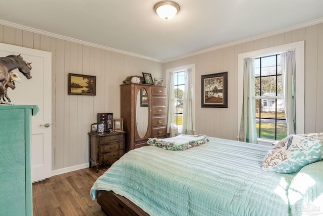 bedroom featuring baseboards, ornamental molding, and wood finished floors