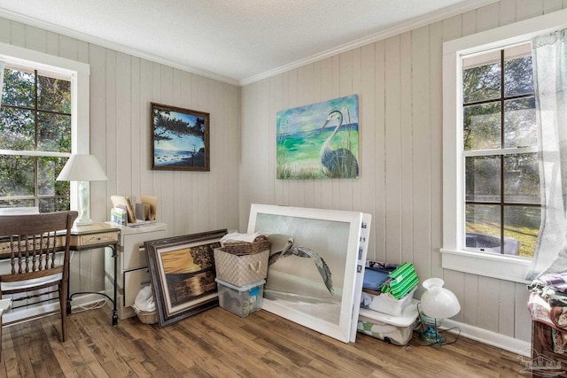 sitting room featuring baseboards, wood finished floors, and crown molding