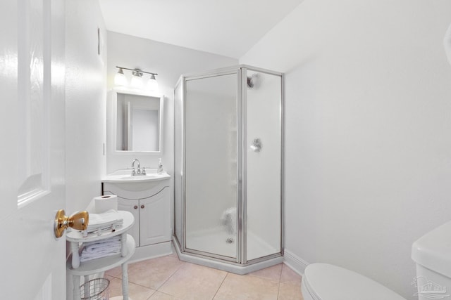 bathroom featuring tile patterned flooring, a shower with door, vanity, and toilet