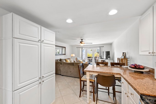 kitchen featuring ceiling fan, white cabinets, and stainless steel range oven