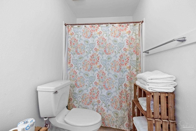 bathroom with a shower with curtain and toilet