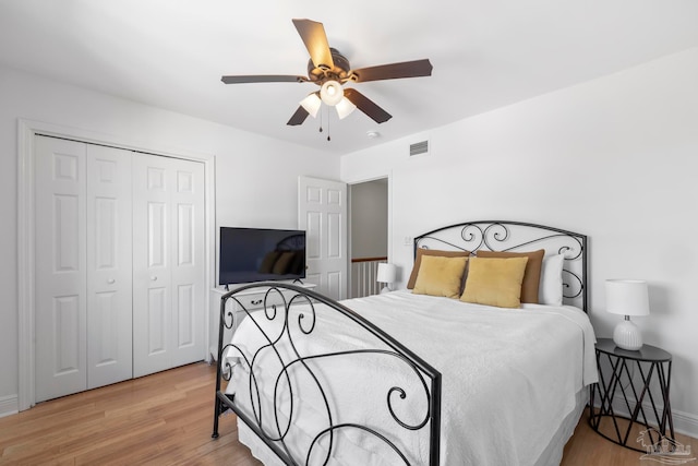 bedroom with ceiling fan, a closet, and light hardwood / wood-style floors